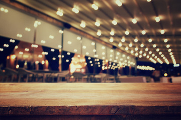 wooden table in front of abstract blurred restaurant lights