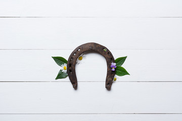 Horseshoe, used and with rust, on white painted wood, symbol for