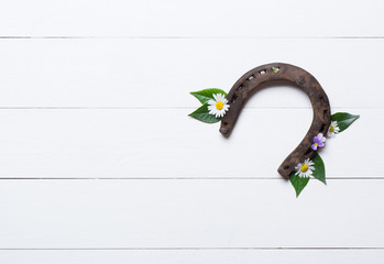 Horseshoe, used and with rust, on white painted wood, symbol for