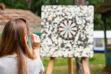 girl playing darts , focus on near-term