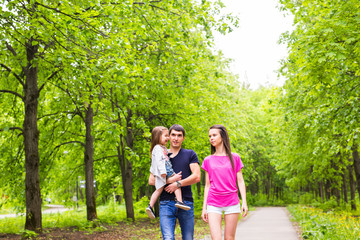 Happy young family walking in green nature.