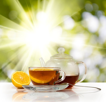 image of cups with tea and lemon on sunlight background