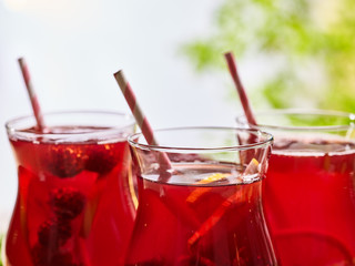 On wooden boardspart of ice cold beverage glass with red raspberry lemon cocktail . Part of alcohol country cocktail beverage number two hundred and nine with mint. Group cocktails on outdoor.