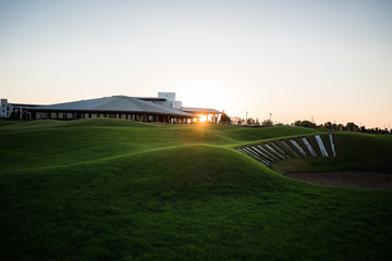 Beautiful golf club house with rays of sun at sunset