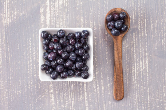 Spoon and  bowl with fresh blueberries