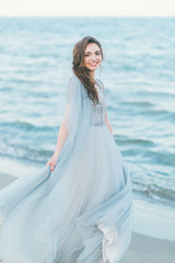 Fototapeta na wymiar Cheerful bride spinning around at the seashore