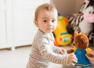Fototapeta premium Baby boy plays with toy in his room.