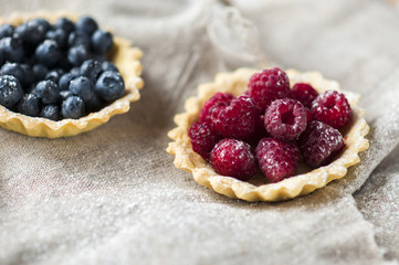 .baked sand basket with fresh berries on tablecloth.