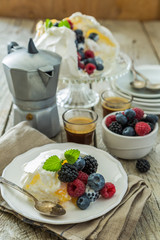 Pavlova with berries and coffee