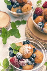 Breakfast, with cottage cheese balls with raspberry, blackberry and blueberry and mint on light table.  Toned and processing photos with soft selective focus. Shallow depth of field