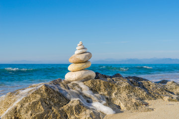 Stones pyramid on sand symbolizing zen, harmony, balance. Ocean