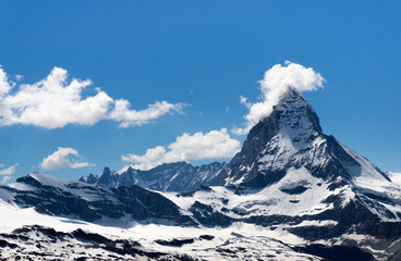 Matterhorn mountain with few cloud cover at the peak, snow patch