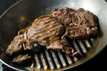 Grilling steak on grill pan. Beefsteak cooking on a kitchen. Fresh, delicious, spicy, juicy meat with copy space closeup.