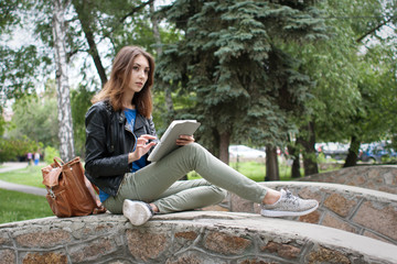Girl sitting in the park with a computer