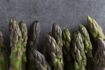 Bunch of asparagus on a table. Uncooked pile raw for organic, vegetarian cuisine, delicious fresh, healthy ingredient. Closeup and copy space.
