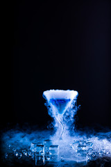 Obraz na płótnie Canvas blue cocktail with splash and ice vapor