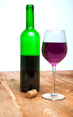 Wine glass and bottle on a wooden table