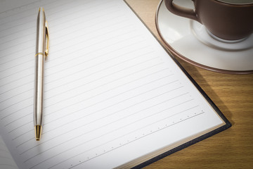 Pen put on note pad open blank page