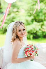 Fototapeta premium bride in a beautiful veil for the decorated table, summer wedding in the style of boho. Decorated tree.