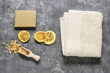 Fototapeta na wymiar Spa set: sea salt, bar of soap and dried oranges on stone