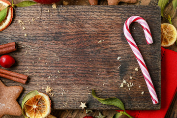 Candy cane and other christmas sweets on wooden background