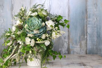 Floral arrangement with succulent, freesia and moss.
