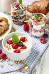 Breakfast table: bowl of yogurt with muesli and fresh fruits