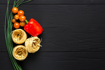 pasta and vegetables on black background