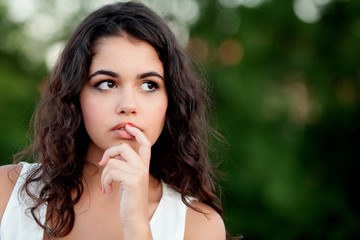 Pensive beautiful brunette girl relaxing in the park