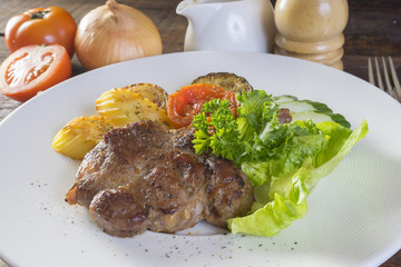 pork steak with vegetable on a white plate