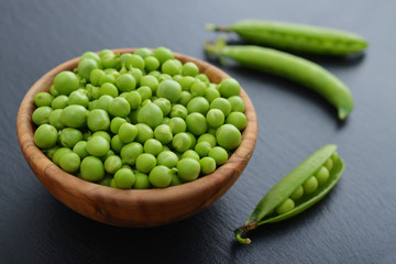Green peas in wooden bowl