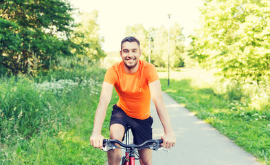 happy young man riding bicycle outdoors