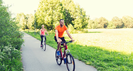 Naklejka premium happy couple riding bicycle outdoors