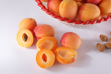 Apricots in a bowl and cut apricot and pits