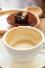 Cup of coffee on wooden table with confectioners atmosphere.