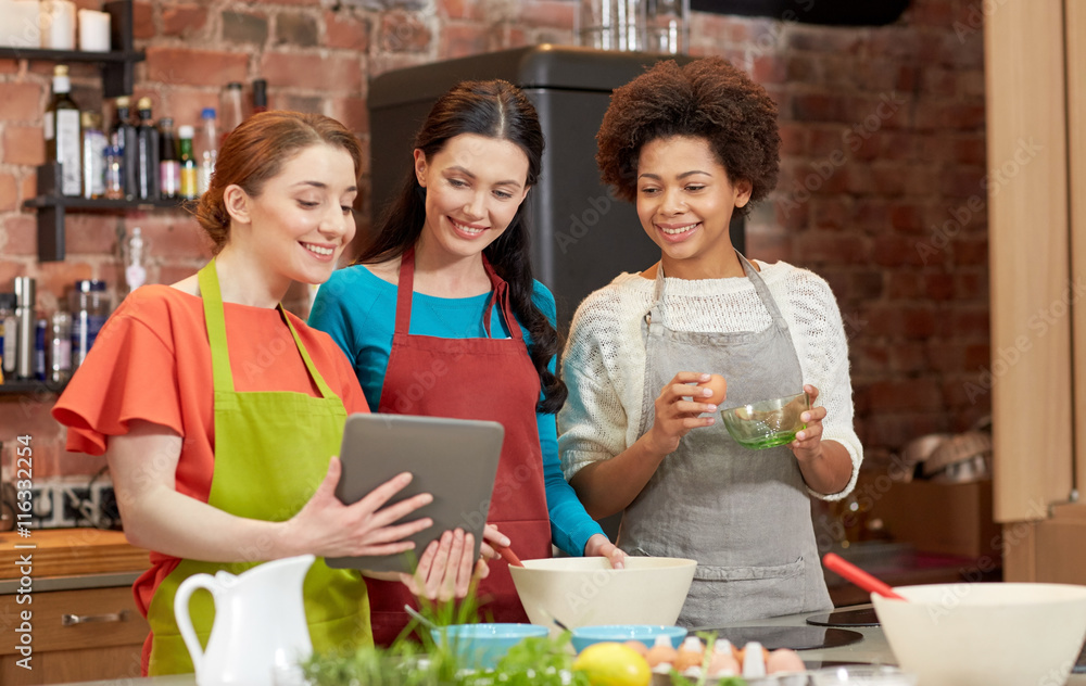 Poster happy women with tablet pc cooking in kitchen