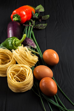 pasta and vegetables on black background
