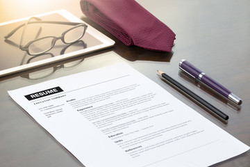 Resume information, with pen, necktie and glasses.