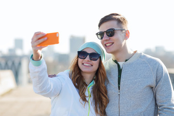 smiling couple with smartphone taking selfie