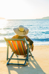 Woman relaxing in deck chair on the beach