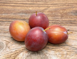 plums isolated on wooden background