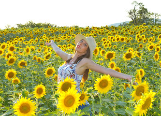 Fototapeta premium Young woman in sunflower field