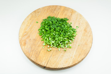 A chopped green onions on a wooden chopping board