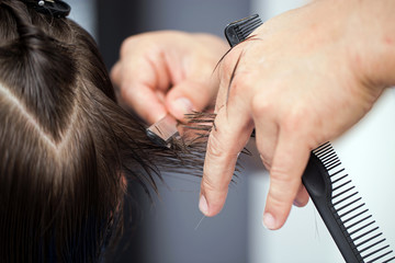 Naklejka premium Ścinanie włosów brzytwą, dłonie fryzjera ścinającego włosy