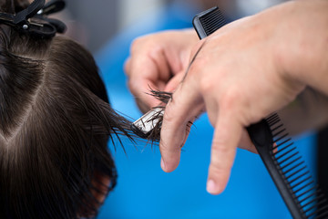 Ścinanie włosów brzytwą, dłonie fryzjera ścinającego włosy - obrazy, fototapety, plakaty