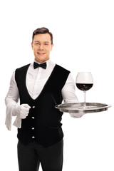 Waiter holding a tray with red wine