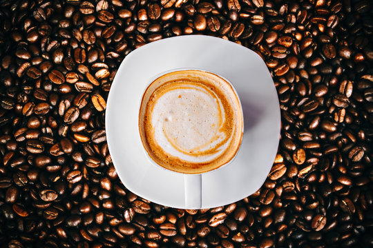 Hot Coffee and with clock sign in white cup Glittering of coffee beans vintage and vignete tone 
