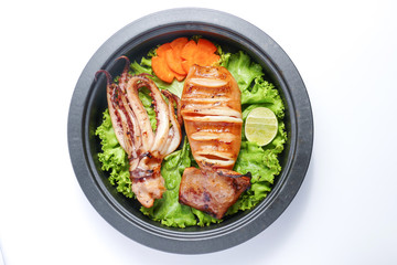 Grilled squid and vegetable on frying pan over white background