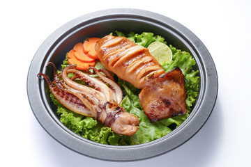 Grilled squid and vegetable on frying pan over white background