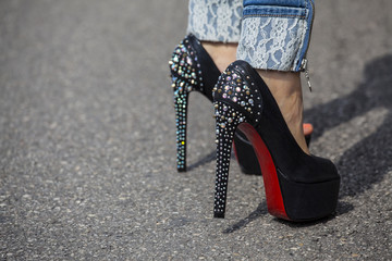 Woman feet with high heels shoes with red sole